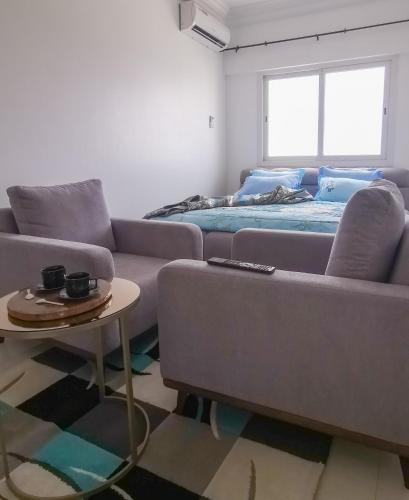 a living room with a couch and a bed at Chambres meublées Avenue Cheikh Anta Diop in Dakar