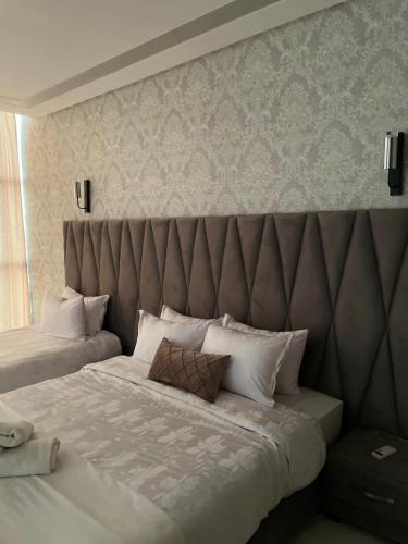 a bedroom with two beds with a large headboard at Hotel Golden Star in Taounate