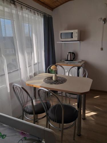 a table and chairs in a room with a kitchen at Pokoje u Bożeny in Karwia