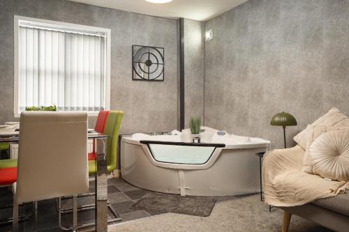 Lovely Getaway Apartment: Two-Bedroom in Rotherham في روثيرهام: حمام مع حوض وطاولة وأريكة