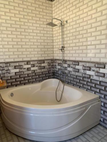 uma banheira branca na casa de banho com azulejos cinzentos em A luxury apartment in Alexandria em Alexandria