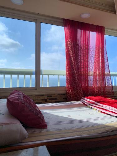 um quarto com uma cama e uma janela com cortinas vermelhas em A luxury apartment in Alexandria em Alexandria