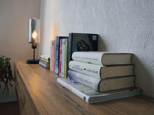 una pila de libros sentados en un estante en Serenity Ferienwohnungen in Gotha en Gotha