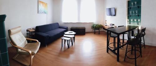 ein Wohnzimmer mit einem blauen Sofa und einem Tisch in der Unterkunft Serenity Ferienwohnungen in Gotha in Gotha