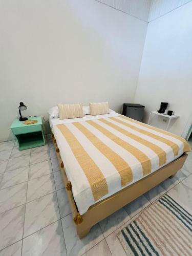 a bedroom with a bed with a striped comforter at Hotel Exotic Lodge in Puerto Viejo