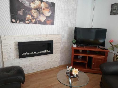 a living room with a fireplace and a tv at Pokoje u Bożeny in Karwia