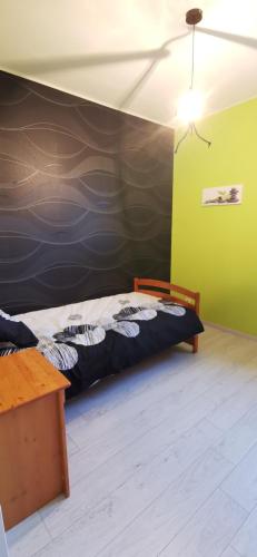 a bedroom with a bed in a room with green walls at Ty Caromel in Cléder