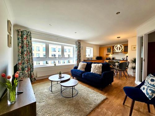 a living room with a blue couch and a table at Kiwi Tree Serviced Apartment in Cambridge