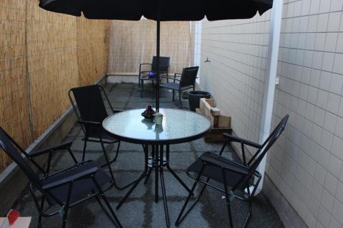 einen Tisch mit Stühlen und einen Regenschirm in einem Zimmer in der Unterkunft Beautiful and Cosy Room in Villejuif