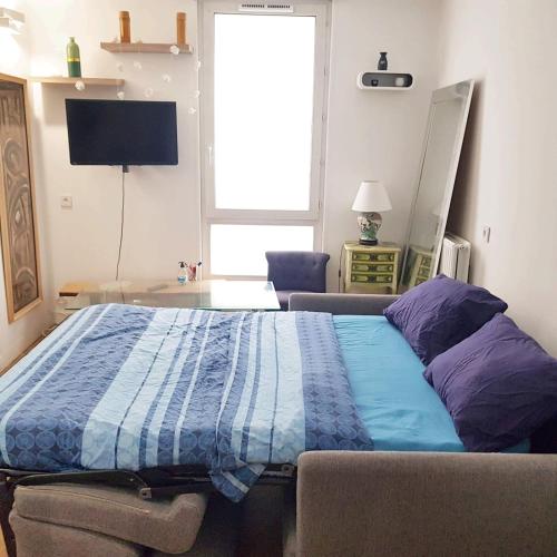 Schlafzimmer mit einem Bett mit blauer Decke in der Unterkunft Beautiful and Cosy Room in Villejuif