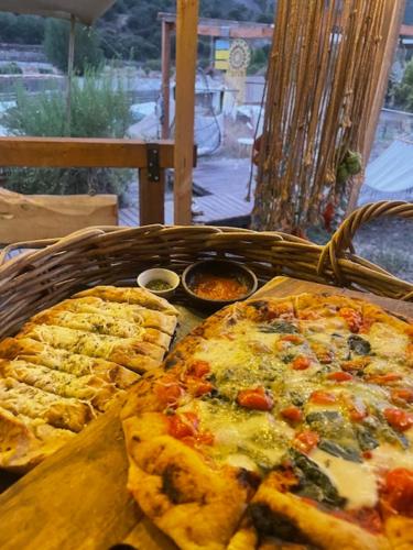 due pizze in un cesto su un tavolo di La villa Glamping a San José de Maipo