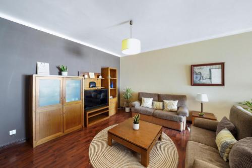 a living room with a couch and a table at Ombak Apúlia - Sea view in Apúlia