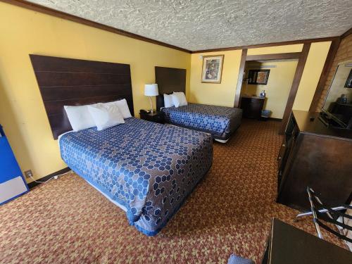 um quarto de hotel com duas camas e uma televisão de ecrã plano em Carthage Inn em Carthage