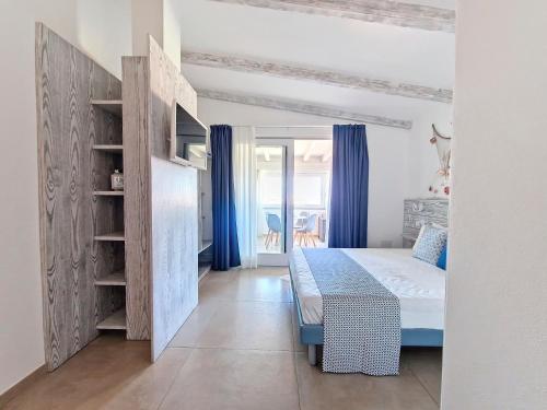 a small bedroom with a bed and blue curtains at L'onda marina in Castelsardo
