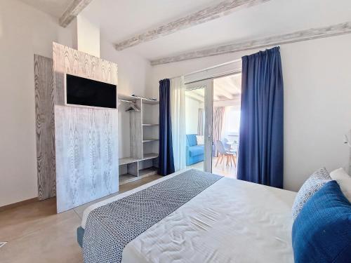 a bedroom with a bed and a tv on a wall at L'onda marina in Castelsardo