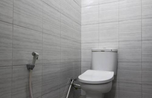 een badkamer met een wit toilet en een douche bij Wisma Alda in Kedaton