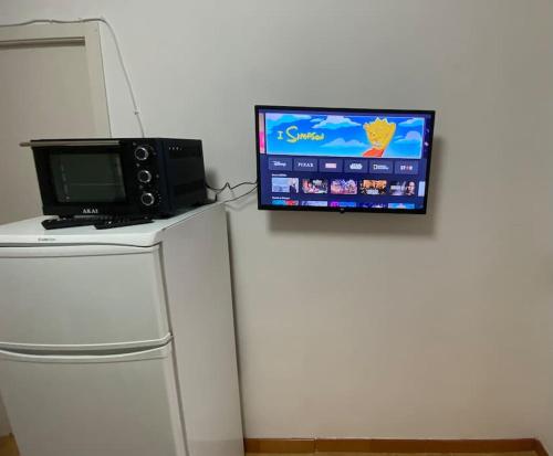 uma televisão em cima de um frigorífico com um micro-ondas em Loft Marinella l'aereoporto di Lamezia sul mare Kitesurf em SantʼEufemia Lamezia