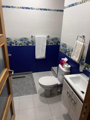 een blauwe en witte badkamer met een toilet en een wastafel bij Villa SKYVIEW in Beni Mellal
