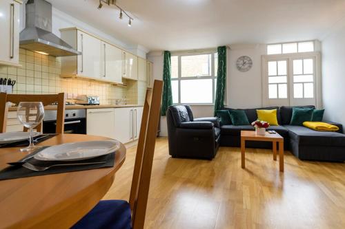 een keuken en een woonkamer met een bank en een tafel bij Spectacular 3 Bed in Blackheath in Londen