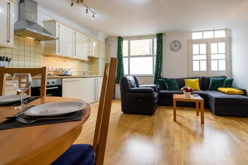 a kitchen and living room with a couch and a table at Spectacular 3 Bed in Blackheath in London