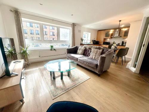 a living room with a couch and a glass table at Kiwi Tree Serviced Apartment in Cambridge