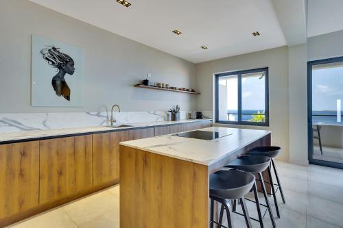 a kitchen with a island with bar stools at SENSES Boutique Hotel & Apartments in Kralendijk
