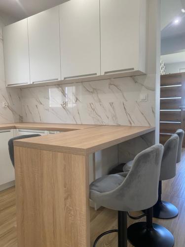 a kitchen with a table and two chairs and white cabinets at Biebrzańska Przystań 3 in Goniadz