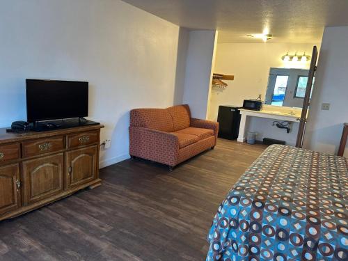 a hotel room with a bed and a chair and a television at Rama Inn in Washougal