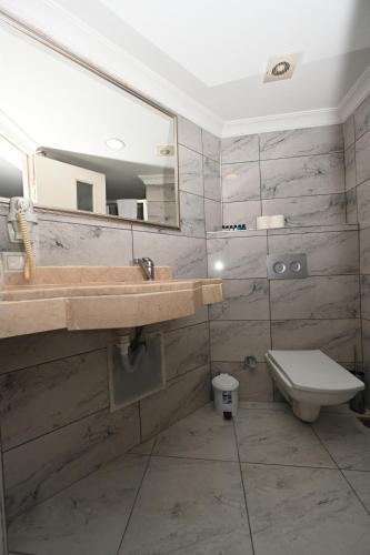 y baño con lavabo, aseo y espejo. en Albatros İstanbul en Estambul