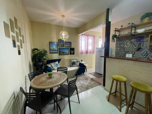 Apartamento BEIRA MAR في فورتاليزا: مطبخ وغرفة معيشة مع طاولة وكراسي