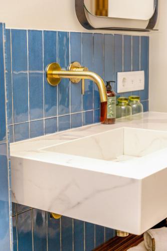 a white sink with a gold faucet in a kitchen at SENSES Boutique Hotel & Apartments in Kralendijk