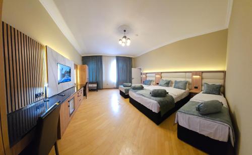 a hotel room with two beds and a flat screen tv at Old City Ganja in Ganja