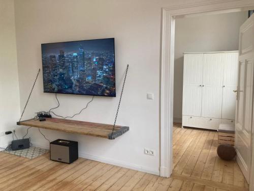 ein Wohnzimmer mit einem an der Wand hängenden TV in der Unterkunft Zentrale Altbau-Wohnung mit Charme in Hannover