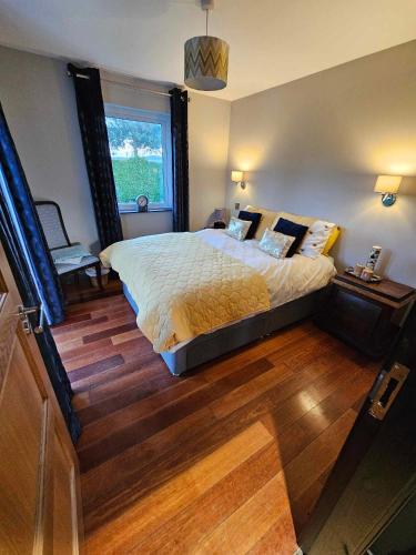 een slaapkamer met een groot bed en een raam bij Harmony Cottage in Eglinton