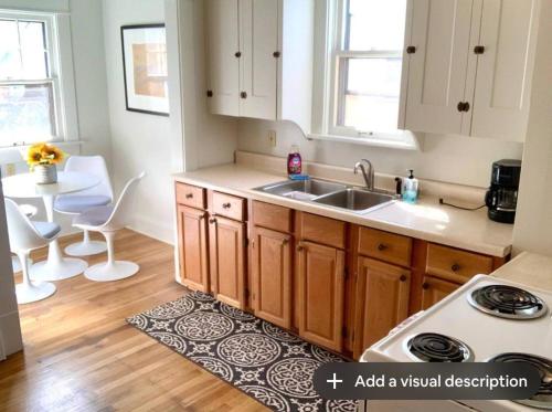uma cozinha com um lavatório e uma mesa em The House Hotels - Thoreau 2 em Lakewood