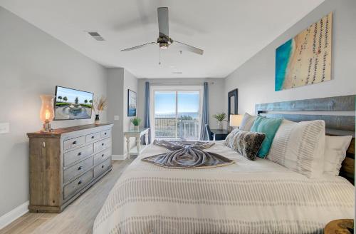 um quarto com uma cama com uma cómoda e uma janela em Ocean Blvd 102 Beautiful Condo with Ocean Views em Isle of Palms