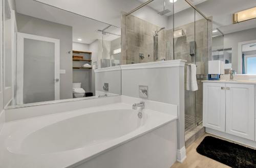 uma casa de banho branca com uma banheira e um chuveiro em Ocean Blvd 102 Beautiful Condo with Ocean Views em Isle of Palms