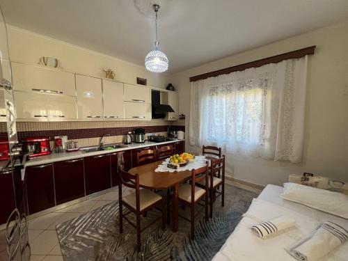 a kitchen with a table and chairs in a kitchen at G.L. Apartments in Berat