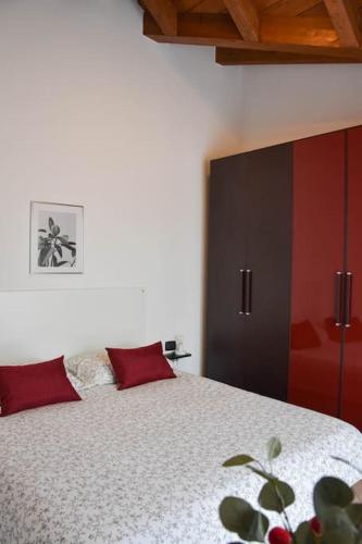 a bedroom with a large bed with red pillows at CA' GIALLA 5 - sul Lago di Lugano, Dog friendly, Balcone & Parcheggio - in Cadegliano Viconago