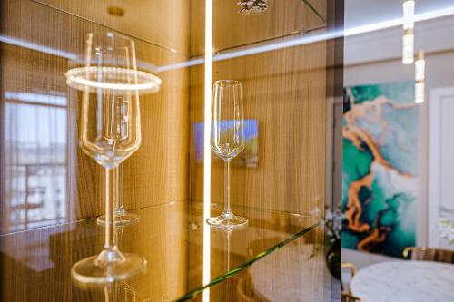 Dois copos de vinho numa prateleira numa sala em New Oasis Premier-Inn flats em Chisinau
