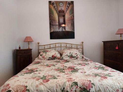 - un lit avec une couette à fleurs et 2 tables de chevet dans l'établissement Résidence La Cerisaie - Très spacieux et confortable pour ce bel appartement ! MAE-2441, à Aix-les-Bains