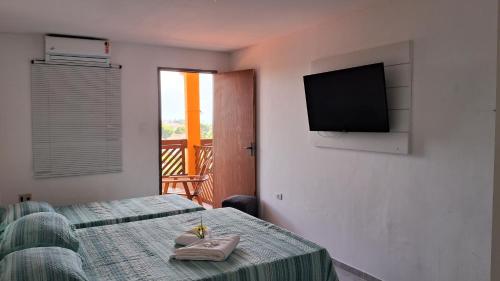 a room with two beds and a flat screen tv at Pousada Recanto da Enseada in Cabo de Santo Agostinho