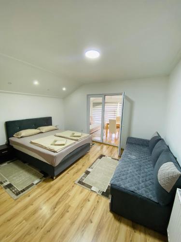 a bedroom with a bed and a couch at Unaqua Apartments in Kulen Vakuf