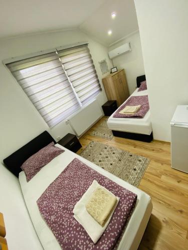two beds in a room with a window at Unaqua Apartments in Kulen Vakuf