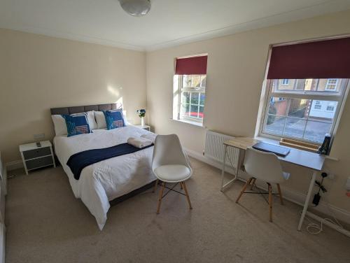 a bedroom with a bed and a desk and two chairs at 83 in Bournemouth