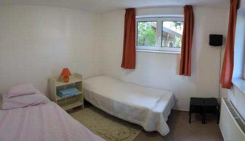 1 dormitorio con 2 camas y ventana en Little Bear Apartment, en Mogyoród