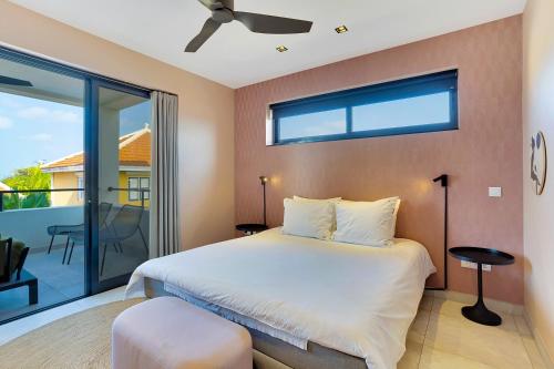 a bedroom with a large bed and a balcony at SENSES Boutique Hotel & Apartments in Kralendijk