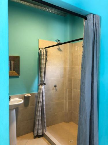 a bathroom with a shower with a shower curtain at CABAÑAS CRAZY COCONUTS in San Antero