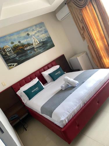 um quarto com uma cama grande e uma cabeceira vermelha em Hotel Yubarta em Buenaventura