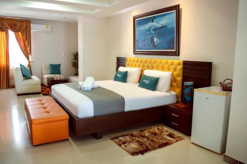 um quarto com uma cama grande e uma cadeira em Hotel Yubarta em Buenaventura